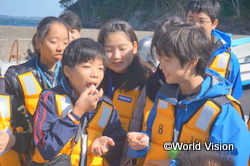 捕れたての帆立をほおばる子どもたち