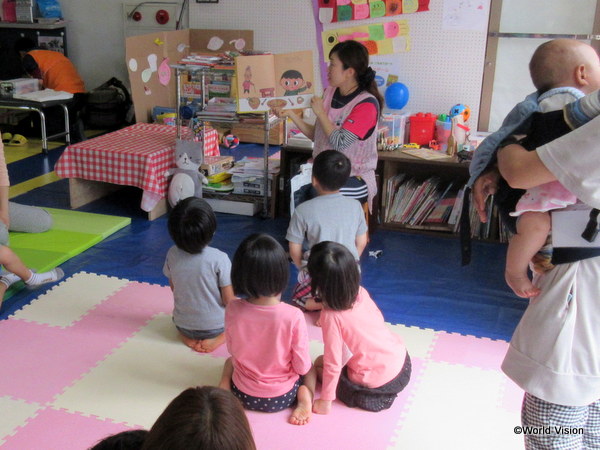 プレイルームでお話に聞き入る子どもたち