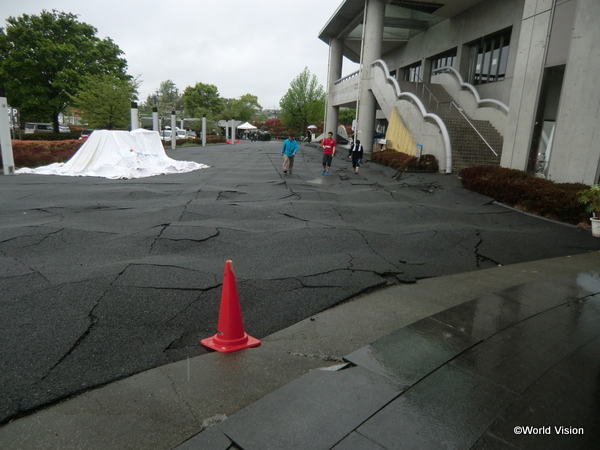 亀裂が入り波打つ益城町総合体育館敷地内の道